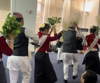 People in Indigenous Himalayan clothing doing a dance for an audience.