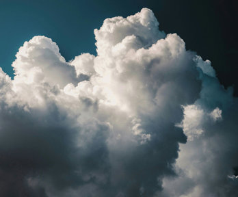 White fluffy clouds in a dark blue almost black sky. 