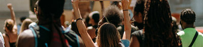 A group on people protest in the middle of the street with a one individual holding a sign that says 'enough'.