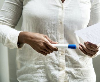 Close-up of a researcher holding a piece of paper and pen. 