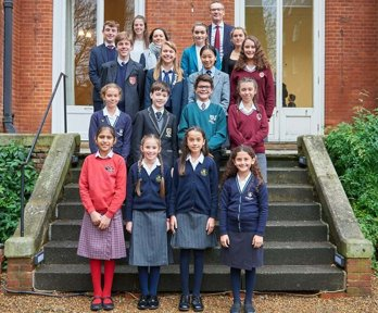A selection of students who have won the Young Geographer of the Year competition standing on the steps of the Royal Geographical Society