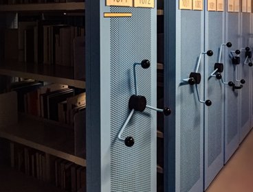 A row of blue metal shelves containing books