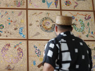 Hormazd Narwiella as seen from behind, standing in front of his mural at the Society and viewing it.