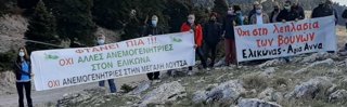 A group of people holding up two large banners in Greek. 