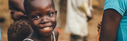 A group of Africa children looking to camera. One girl is focused on particularly and she is smiling