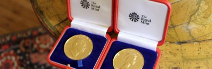 Two royal medals sitting on a floor globe