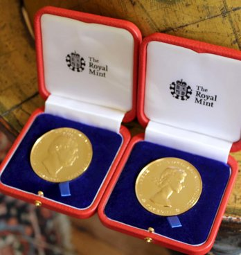 Two royal medals sitting on a floor globe