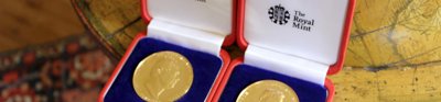 Two royal medals sitting on a floor globe