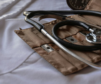 A stethoscope lays on its brown leather holder.