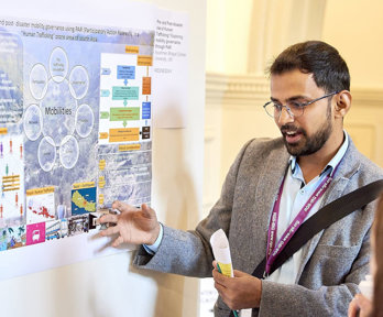 A person presenting his poster to conference delegates.