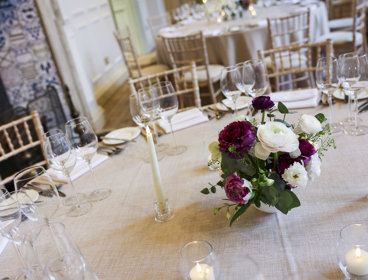 Flowers, candles and wine glasses on the table for wedding set up