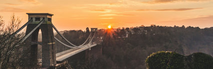 Bridge over a goirge with a sunset background