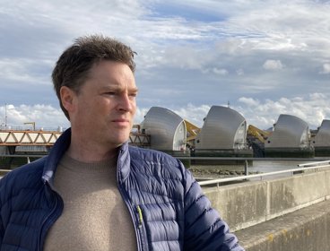 Mark Maslin standing in front of the Thames Barrier