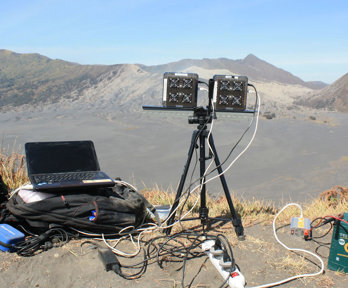 Laptop and UV monitoring equipment in mountainous landscape.