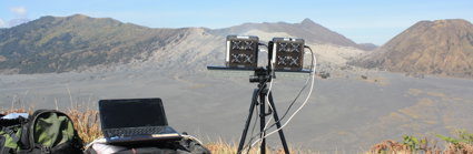 Laptop and UV monitoring equipment in mountainous landscape.