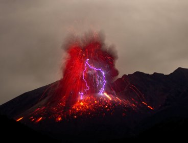 A volcano erupting, causing lightning to occur