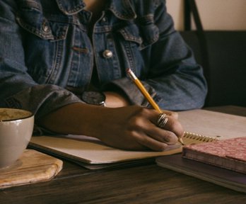 Person writing on paper notebook