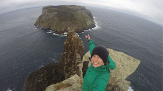 Phoebe Smith taking selfie on the edge of island.