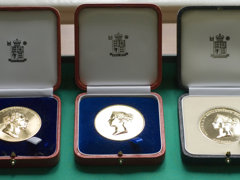 Three Society medals displayed in wooden boxes.