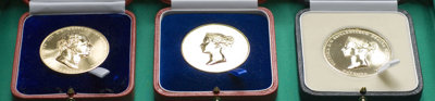 Three Society medals displayed in wooden boxes.