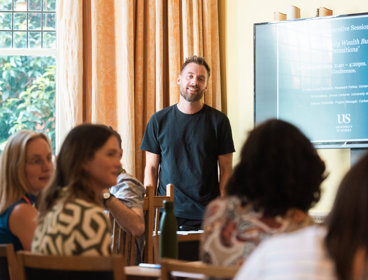 Person presenting to an audience in a casual environment.