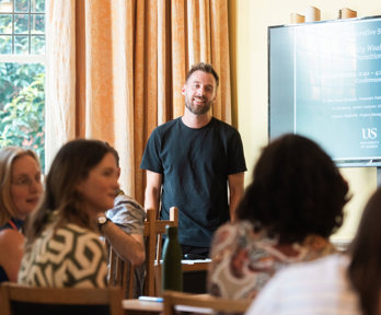 Person presenting to an audience in a casual environment.