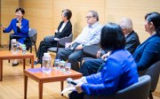 A group of speakers sitting on a stage as part of a panel.