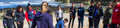A group of students on a training course. They are standing on a beach