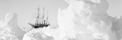 Old black and white photograph of the Endurance ship stuck in ice.