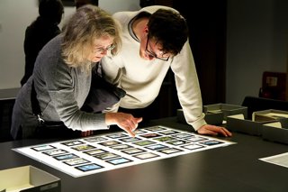 Two people looking over a light box at photographic negative slides