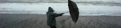 erson Holding Umbrella On Windy Beach