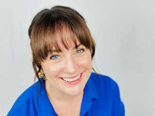 Headshot of Natalie Hewit wearing a bright blue shirt. 