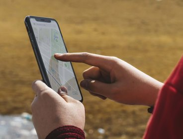 Hands holding a phone that shows a map on the screen