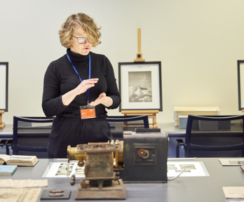 A table with books, glass slides, and scientific instruments