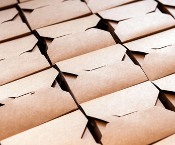 Folded cardboard boxes stacked in rows.