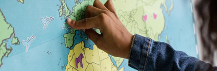 A child pointing to the UK on a map of the world.