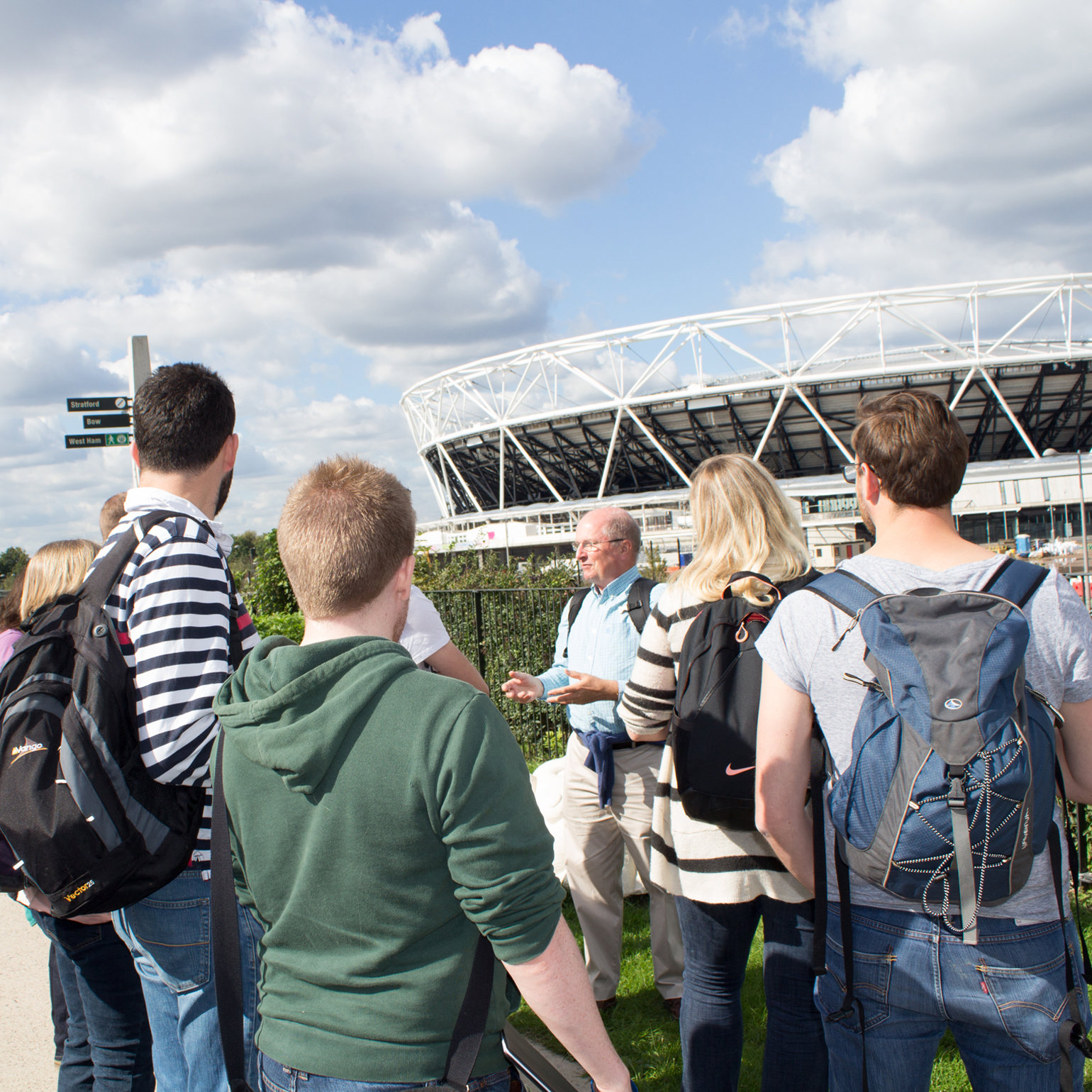 A group of teachers standing outside the London 2012 Olympic stadium in Stratford, London. They are being guided by a fieldwork expert in how to lead fieldwork for schools in the area.