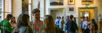 Conference attendees networking in the Main Hall at the Royal Geographical Society.