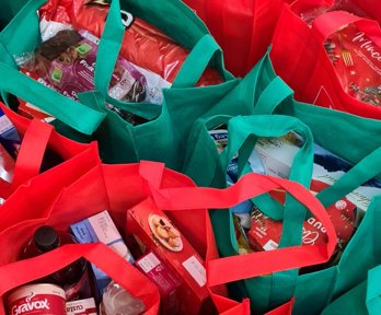 Cluster of shopping bags filled with groceries.