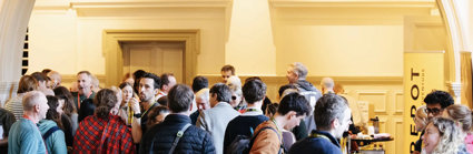 Explore symposium attendees gather in the Main Hall of the Royal Geographical Society to browse the exhibitors' stands.