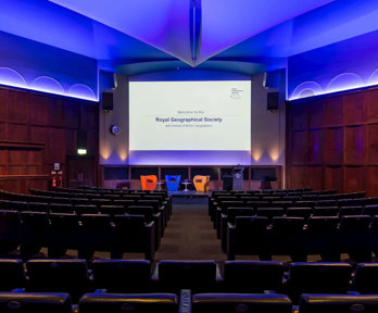 The Ondaatje Theatre at the Society with a screen that says welcome to the Royal Geographical Society.