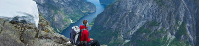 Person looking out across a mountain valley. A river meanders through the valley.