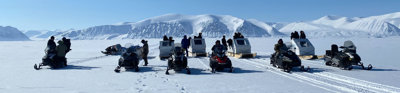 Group of people on snowmobiles in the Arctic. 