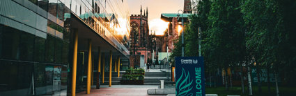 University campus with old and new buildings, with the sun setting in the background