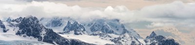 An iceberg over the sea with clouds above