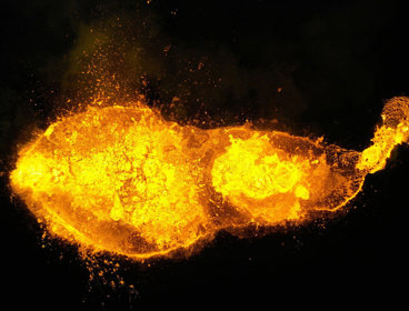 Aerial view of a lava eruption on a black background.