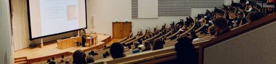 Tiered lecture theatre with speaker presenting at the front