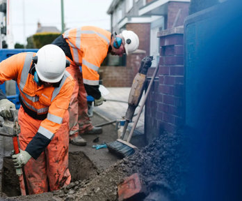 Construction worker digging hole into ground.