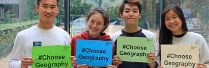 Four young people holding up signs with the text Choose Geography.