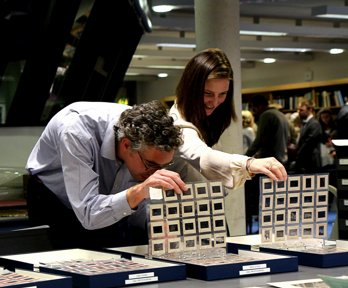 A man and a woman looking at sheets of photographic negatives